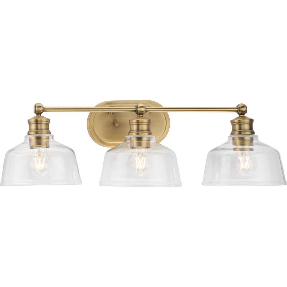 Singleton Collection Three-Light 26.5&#34; Vintage Brass Farmhouse Vanity Light with Clear Glass Sha